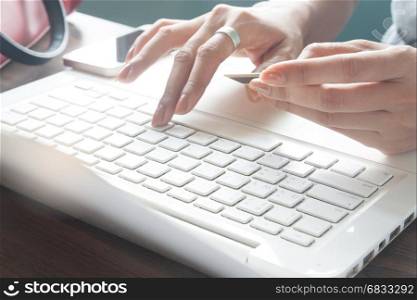 Woman typing on laptop keyboard and holding credit card, Online marketing concept