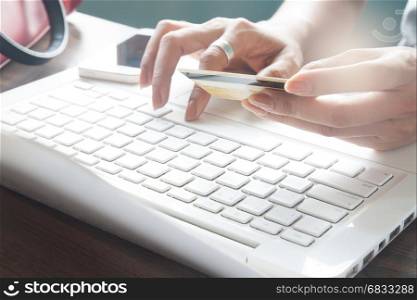 Woman typing on laptop keyboard and holding credit card, Online shopping concept