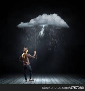 Woman under rain. Young woman in casual holding raining cloud on rope