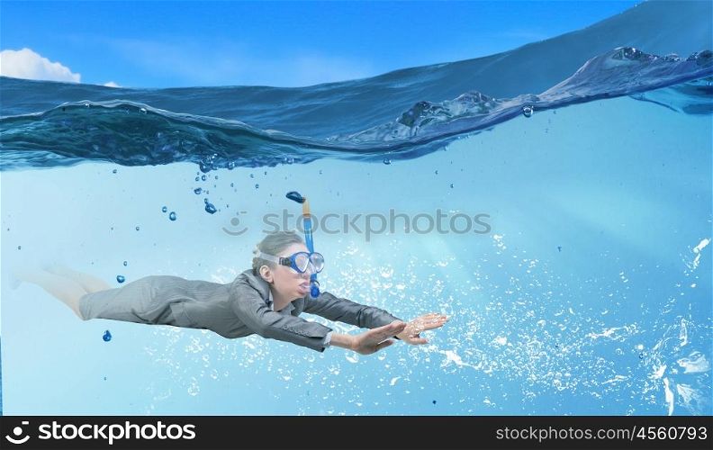 Woman under water. Businesswoman in suit and mask swimming under water