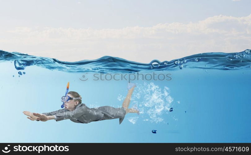 Woman under water. Businesswoman in suit and mask swimming under water