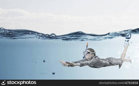 Woman under water. Businesswoman in suit and mask swimming under water