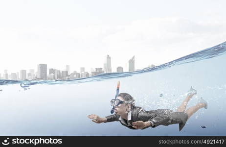 Woman under water. Businesswoman in suit and mask swimming under water