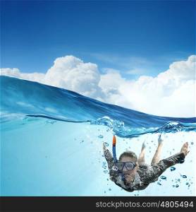Woman under water. Young businesswoman in suit and diving mask swimming under water