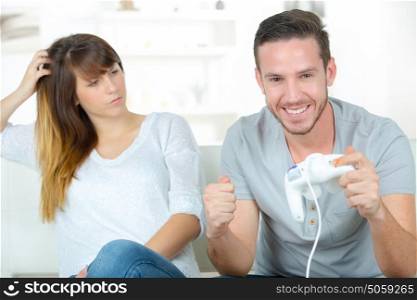 woman unhappy with her husband playing video-games