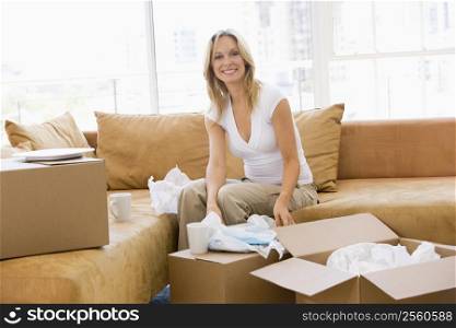Woman unpacking boxes in new home smiling