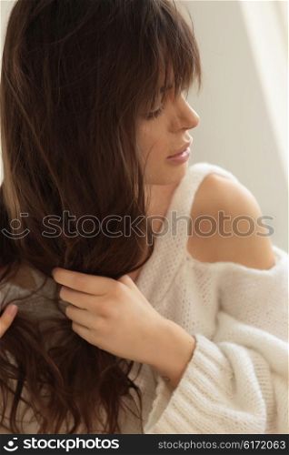 Woman untangles hair. Natural portrait.