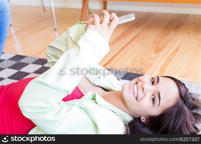 Woman updating her social networks while relaxing in the living room