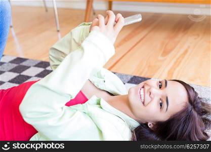 Woman updating her social networks while relaxing in the living room