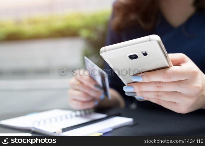 Woman use credit cards to shop online via mobile phones.
