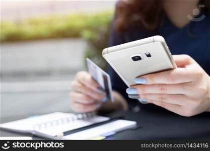 Woman use credit cards to shop online via mobile phones.