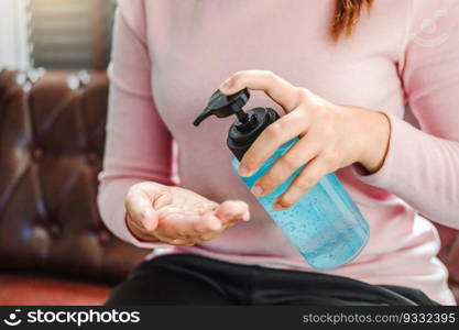 Woman using a hand sanitizer alcohol gel to wash hands to prevent viruses and diseases at home