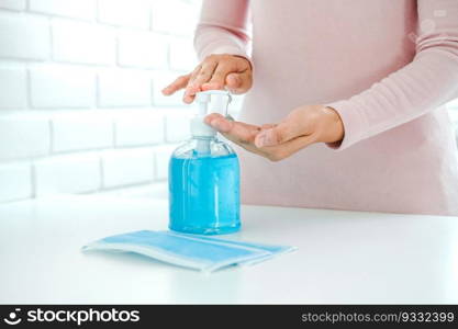 Woman using a hand sanitizer alcohol gel to wash hands to prevent viruses and diseases at home