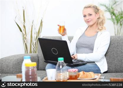 Woman using a laptop at breakfast time