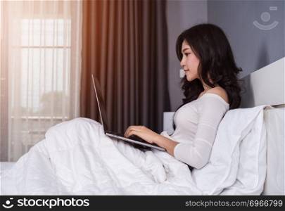 woman using a laptop computer on bed