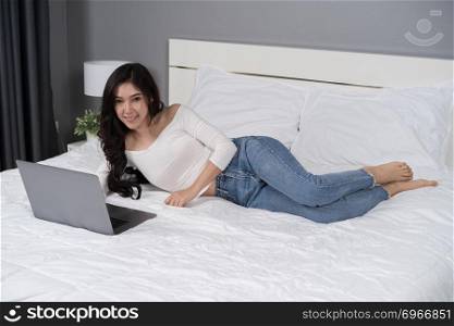 woman using a laptop computer on bed