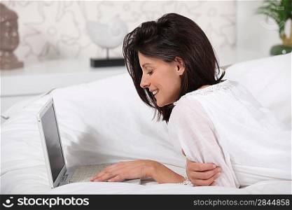 Woman using a laptop on a sofa