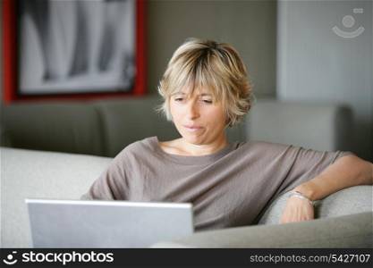 Woman using a laptop on the sofa