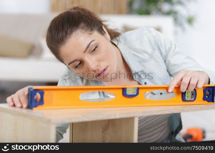 woman using a level on furniture