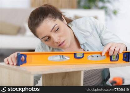 woman using a level on furniture