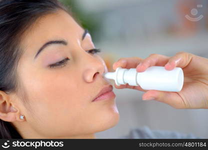 Woman using a nasal spray