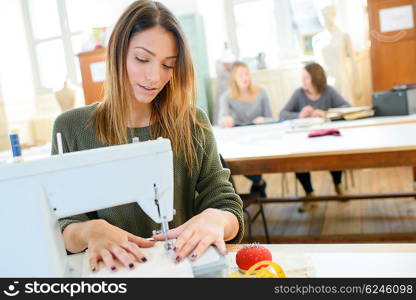 Woman using a sewing machine in class