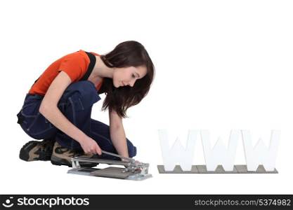 Woman using a tile cutter