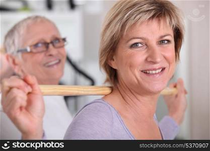 Woman using a wooden stick in a gym