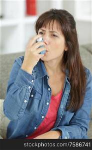 woman using an asthma inhaler
