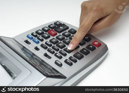 Woman using calculator, close-up of finger