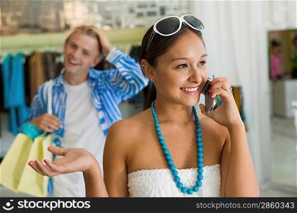 Woman Using Cell Phone in Clothing Boutique