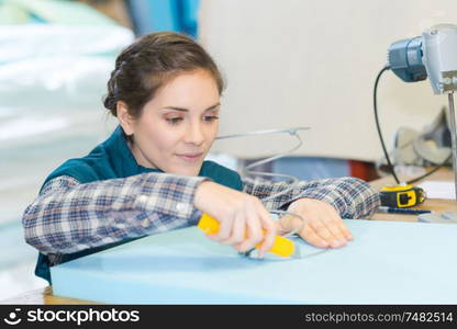 woman using craft knife to cut hole