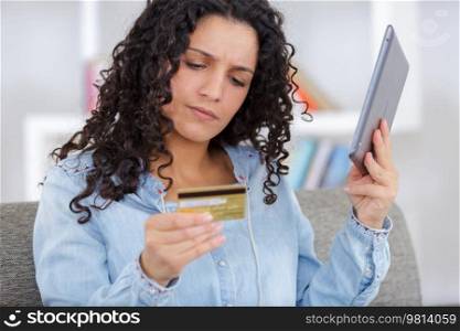 woman using credit card and smartphone to pay online