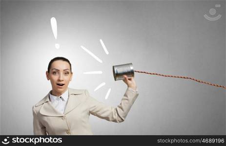 Woman using deaf phone. Young businesswoman using tin can and string as communication tool