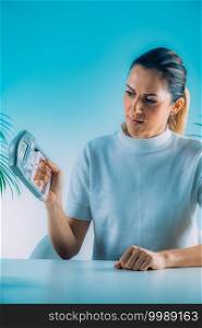 Woman Using Digital Hand Grip Dynamometer and Smart Phone. Woman with Digital Hand Grip Dynamometer and Smart Phone