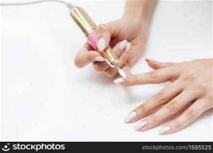 woman using digital nail file high view