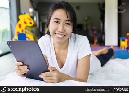 woman using digital tablet in a bed at home. The use of concept of new generation, family, parenthood, authenticity, connection, technology