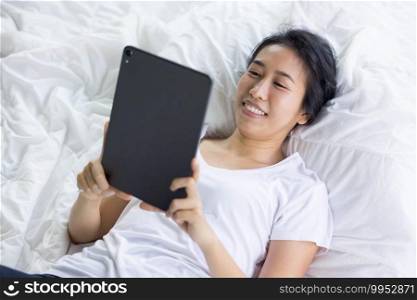 woman using digital tablet in a bed at home. The use of concept of new generation, family, parenthood, authenticity, connection, technology