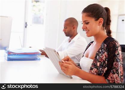 Woman Using Digital Tablet In Office Of Start Up Business