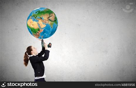 Woman using drill. Emotional businesswoman drilling Earth planet. Elements of this image are furnished by NASA