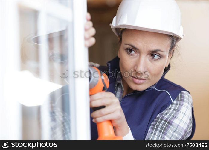 woman using electronic drill install door