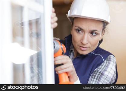 woman using electronic drill install door