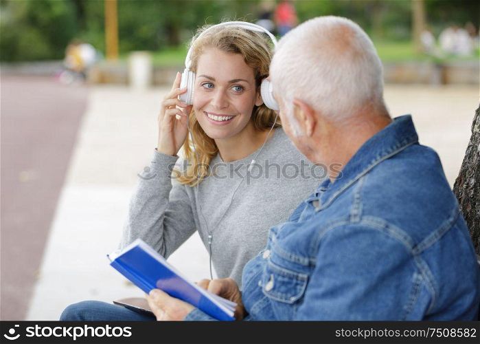 woman using headphones talking to senior dad