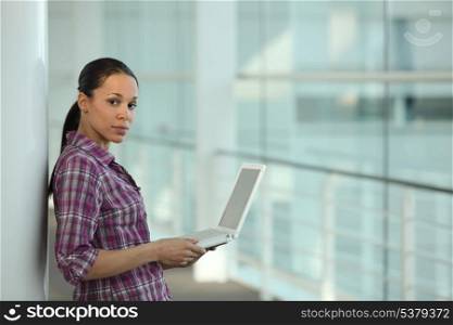 Woman using her laptop in a corridor
