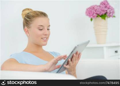 Woman using her tablet computer as she waits for an appointment