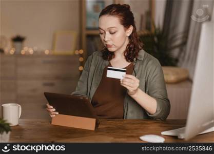 woman using her tablet home with credit card