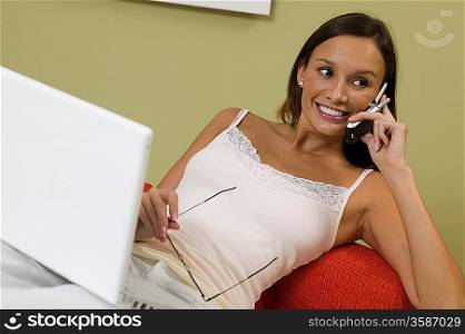 Woman Using Laptop and Cell Phone