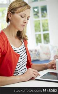 Woman Using Laptop At Home In Kitchen