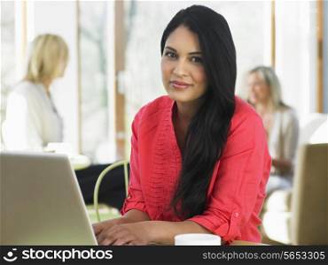 Woman Using Laptop In Cafe