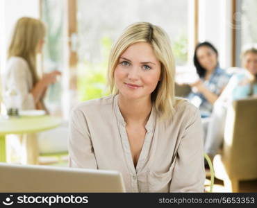 Woman Using Laptop In Cafe